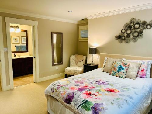 a bedroom with a large bed and a bathroom at Qualicum Landing West Coast Cottage in Qualicum Beach