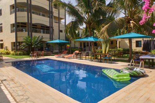 una piscina con sedie e ombrelloni e un edificio di LA Maison Sur Le Fleuve a Bamako