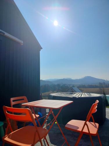 a table and chairs on a patio with a view at Domek Pośród Gór - JACUZZI WLICZONE W CENIE POBYTU,bajeczne widoki, relax i spokój in Laski