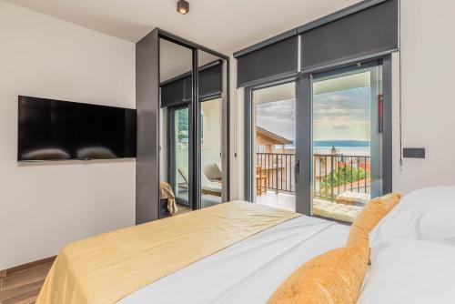 a bedroom with a bed and a view of the ocean at Luxury Villa MAJA in Baška Voda