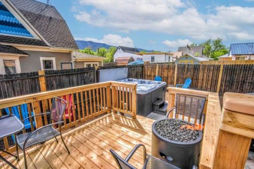 a wooden deck with a grill and chairs on it at The Vibrant Victorian Hot Tub & Fire Pit in OCC in Colorado Springs