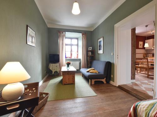 a living room with a blue couch and a table at Historic Apartment in Gerdshagen with Garden in Gerdshagen
