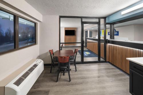 a dining room with a table and chairs in a room at Days Inn by Wyndham Kansas City Northeast in Kansas City