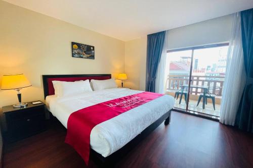 a bedroom with a large bed and a large window at Ramada by Wyndham Phnom Penh Central in Phnom Penh
