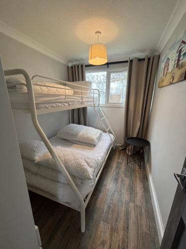 a bedroom with two bunk beds and a window at 88, Two bed Chalet on Belle Aire Holiday Park - sleeps 5, pet friendly, bed linen and towels included plus onsite entertainment available in Great Yarmouth