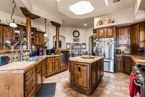 a large kitchen with wooden cabinets and stainless steel appliances at Secluded Retreat Pool Spa Sauna Rooftop Deck in Las Cruces