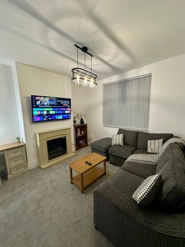 a living room with a couch and a tv at The Beach House in Mablethorpe