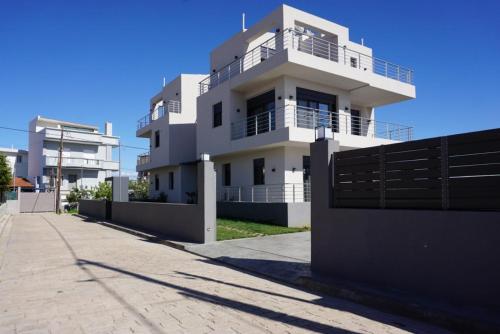 a white building with a fence in front of it at H residence 2 in Artemida