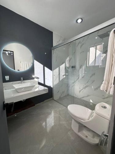 a bathroom with a toilet and a sink and a mirror at AR SUITES Casa Luneta in Zamora de Hidalgo
