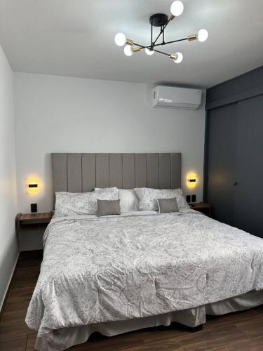 a bedroom with a large bed with a white comforter at AR SUITES Casa Luneta in Zamora de Hidalgo