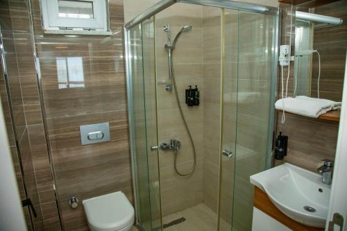 a bathroom with a shower and a toilet and a sink at Sofia Beach Residence in Trabzon
