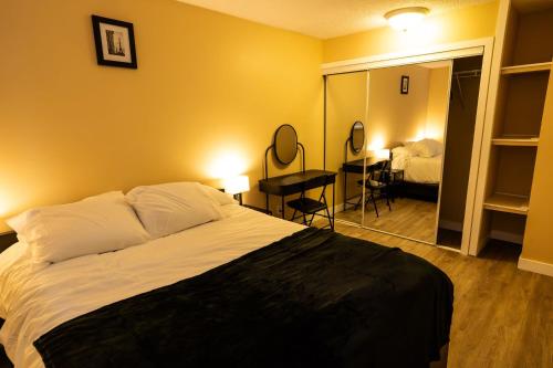 a bedroom with a bed and a desk and a room at Charming 2-Bedroom House in Central Calgary in Calgary