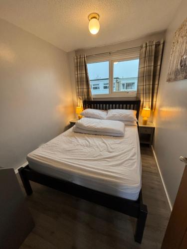a large bed in a room with a window at 246, Two bed Chalet on Belle Aire Holiday Park - sleeps 5, pet friendly, free Wi-Fi, bed linen and towels included plus onsite entertainment available in Great Yarmouth
