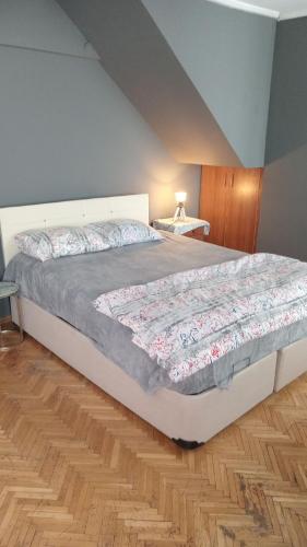 a bedroom with a large bed with a wooden floor at Huzur10 in Edirne