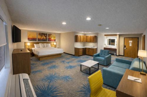 a hotel room with a bed and a living room at Days Inn by Wyndham Sturgis SOUTHDAKOTA in Sturgis