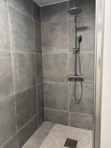 a bathroom with a shower with a shower head at Villa Bäckagård Bed and Breakfast in Åstorp