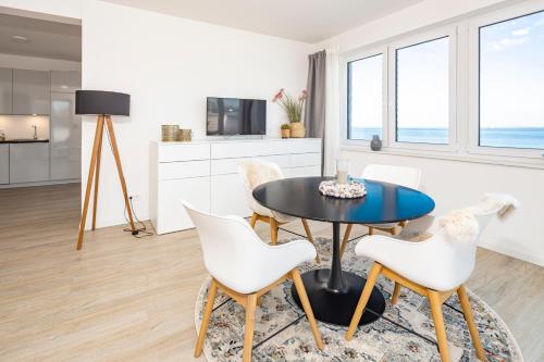 a kitchen and dining room with a table and chairs at Ostsee Suite 2 - Penthouse in Niendorf