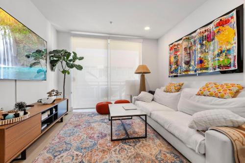 a living room with a white couch and a large painting at 8 Santa Monica Huge Stylish Apartment in Los Angeles