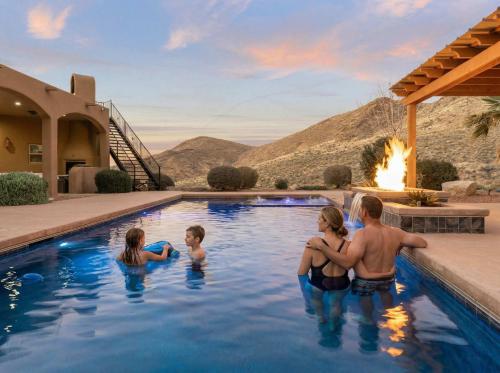 a family in the swimming pool of a house at Secluded Retreat Pool Spa Sauna Rooftop Deck in Las Cruces