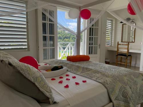 a bedroom with a bed with a baby in a tray of roses at Oasis Marigot Bay in Marigot