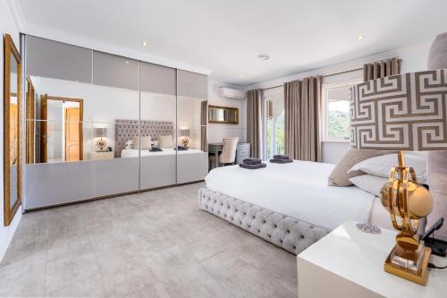 a white bedroom with a large bed and a desk at Casa Lorna in Marbella