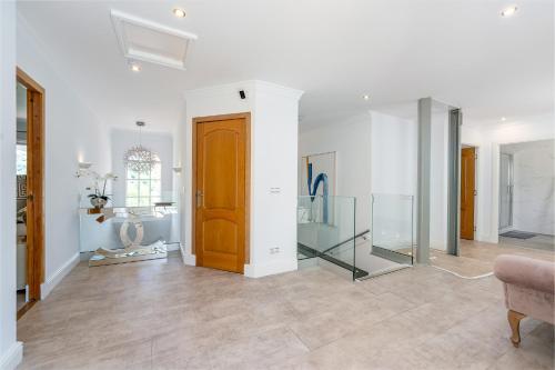 a large white room with a wooden door and a chair at Casa Lorna in Marbella