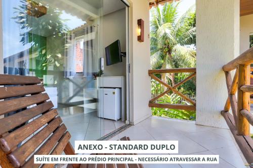 an open door to a balcony with a television at Pousada Terra Mar Way in Barra Grande