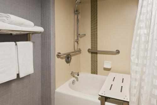 a bathroom with a tub and a shower and a sink at Hyatt Place Boston - Medford in Medford