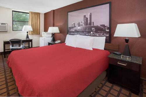 a hotel room with a red bed and a picture on the wall at Super 8 by Wyndham Chicago IL in Chicago