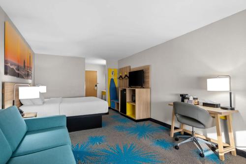 a hotel room with a bed and a desk and chair at Days Inn by Wyndham Imlay City in Imlay City