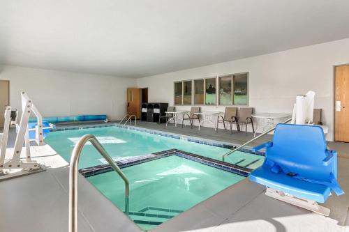 a swimming pool with a blue chair in a hotel room at Days Inn & Suites by Wyndham Castle Rock in Castle Rock