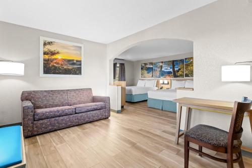 a hotel room with a couch and a bed at Days Inn & Suites by Wyndham Castle Rock in Castle Rock
