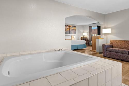 a large white tub in a living room with a couch at Days Inn & Suites by Wyndham Castle Rock in Castle Rock