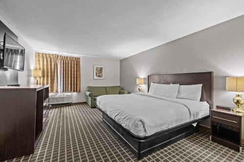 a hotel room with a bed and a couch at Ramada by Wyndham Stevens Point in Stevens Point