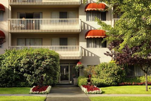 a building with balconies and flowers in front of it at Royal Scot Hotel & Suites, Trademark Collection by Wyndham in Victoria