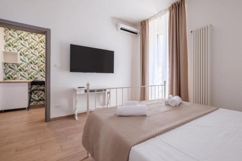 a bedroom with a bed with a television on the wall at Rooms 2Binari in Bologna
