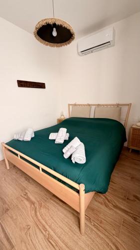 a bed with green sheets and white towels on it at LaViDaViò Suite Room in Bergamo