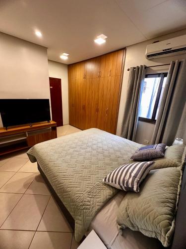 a bedroom with a large bed and a flat screen tv at Duplex Premium - Best Place in CDE in Ciudad del Este