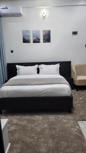 a bedroom with a bed with three pictures on the wall at Aimarck Homes and Suites in Kampala