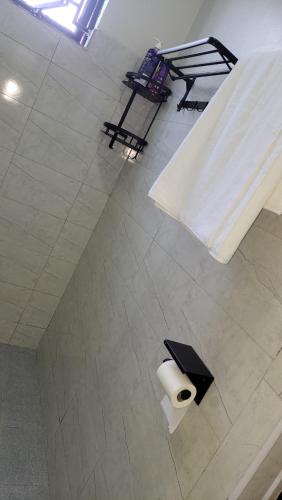 a bathroom with a toilet paper roll on the floor at Aimarck Homes and Suites in Kampala