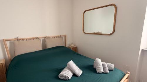 a bedroom with a green bed with towels on it at LaViDaViò Suite Room in Bergamo