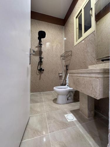 a bathroom with a sink and a toilet at براون هاوس للشقق المخدومة in Quai