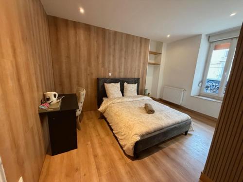 a bedroom with a bed and a desk in it at Hôtel Le Normandie in Le Mans