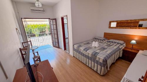 a small bedroom with a bed and a balcony at Ninho dos Passaros Penedo RJ in Penedo