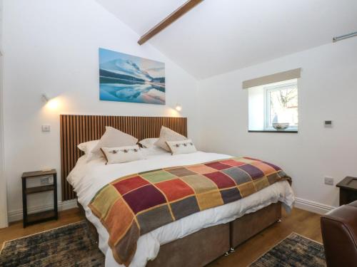 a bedroom with a bed with a colorful blanket at The Studio in Caernarfon