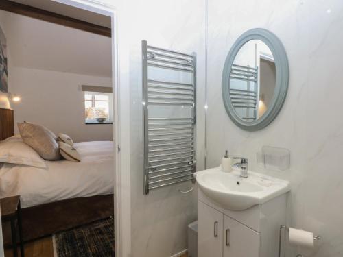 a bathroom with a sink and a mirror and a bed at The Studio in Caernarfon
