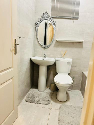 a bathroom with a toilet and a sink and a mirror at Legae la rena in Polokwane