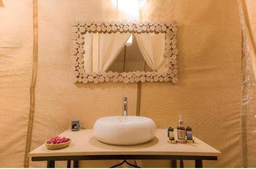 a bathroom with a sink and a mirror at Merzouga Dream Camp in Merzouga