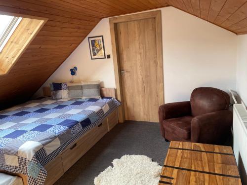 a bedroom with a bed and a chair in a attic at Chalupa u Pepy in Tábor