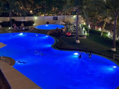 a large pool with blue water at night at Bay View Grand Ixtapa Exclusive in Ixtapa